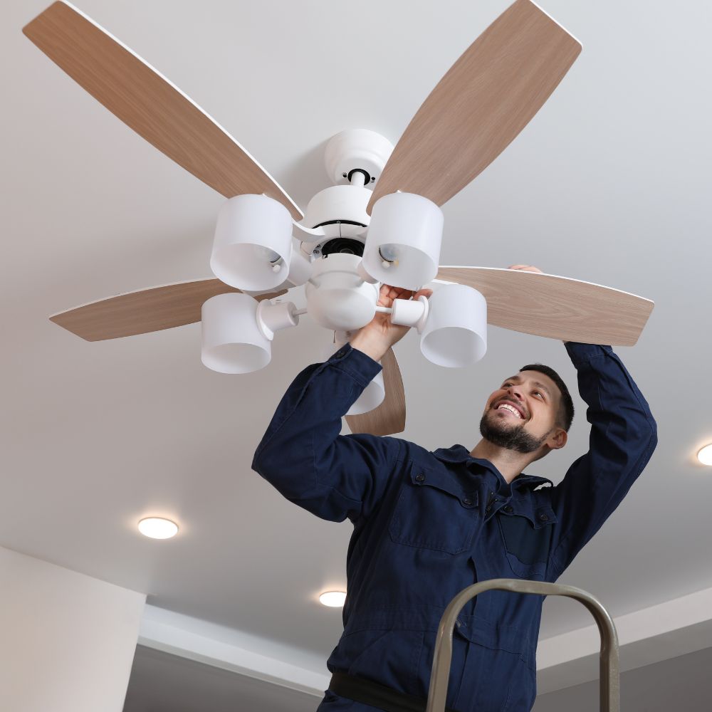 Electrician installing a ceiling fan